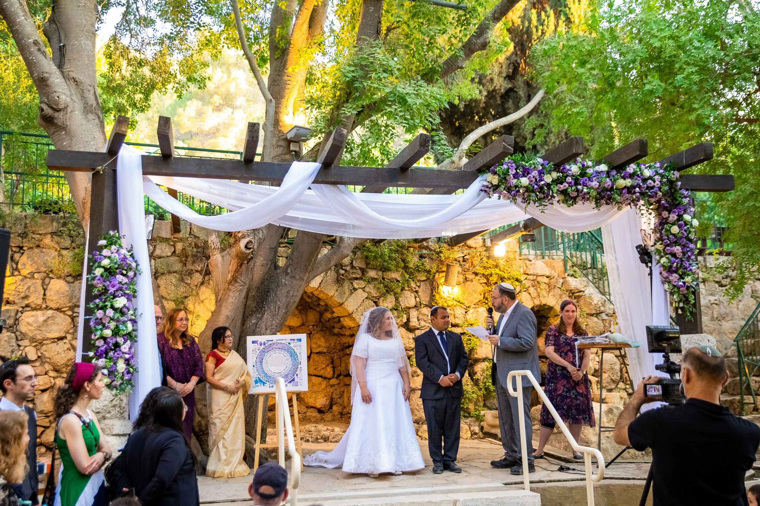 A couple under the chuppah with their modern Ketubah.