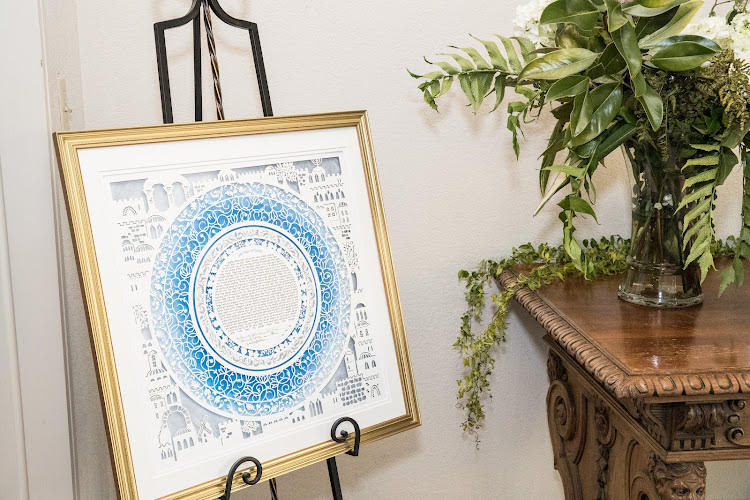 A beautifully framed Ketubah displayed in a home setting.